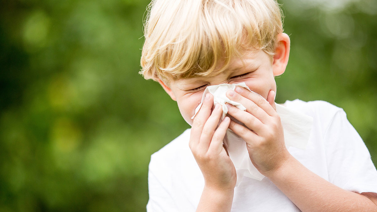 A young boy sneezes. Its allergy season again.