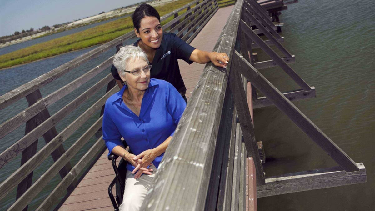 An Amada Senior caregiver with a senior on a bridge looking at a marsh in South Carolina