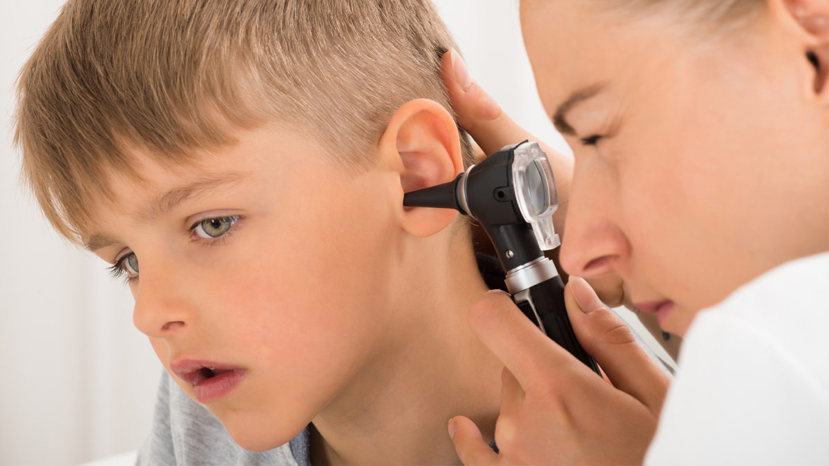 An ENT doctor examines a young boy's ears