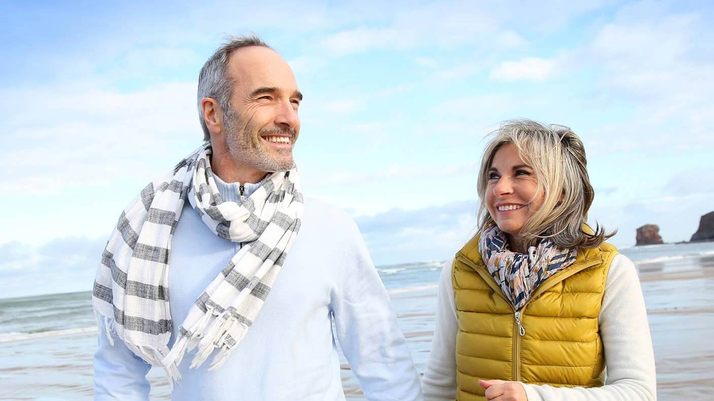 An active couple smiling on the beach