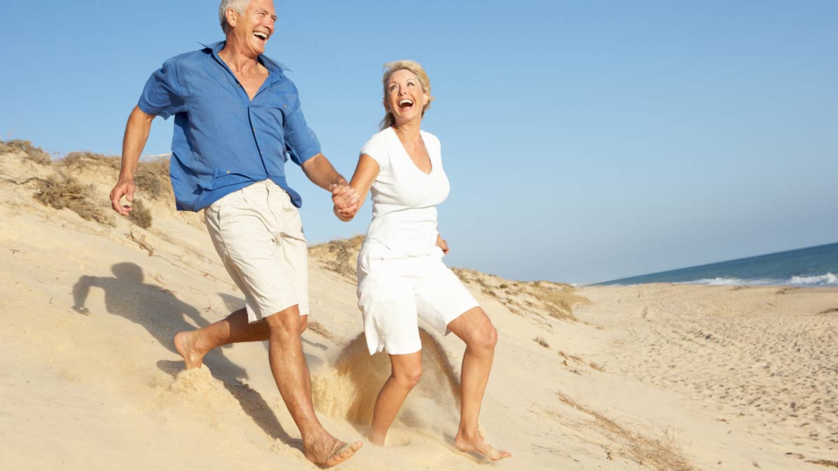 Senior couple running on the beach. On the Quest to a Better Life. Better Life Carolinas Seeks to Optimize Wellness.