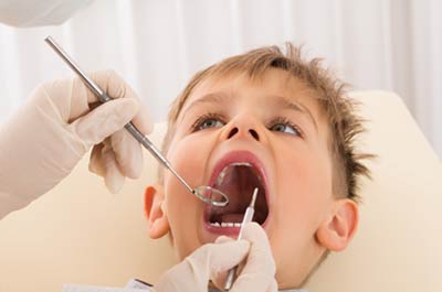 A young boy getting a dental exam. February is National Children's Dental Health Month photo.