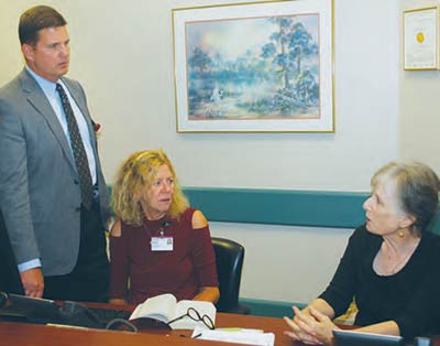 CEO Stephen Porter talks with hospital volunteers Jeanne Bowie, left, and Michaela McIntosh.