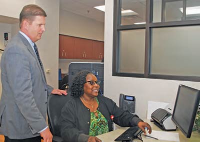 CEO Stephen Porter interacts with Carolyn B. White, one of the hospital’s financial services representatives.