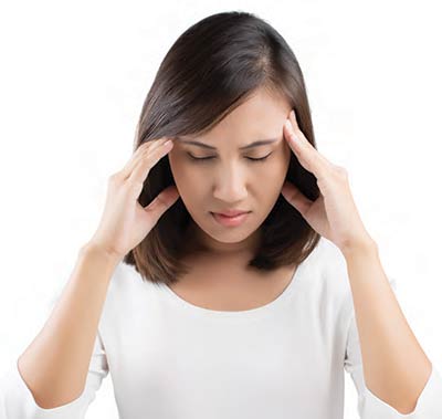 Photo of a woman with a headache. Botox is also used in the treatment of chronic migraines and tension headaches.