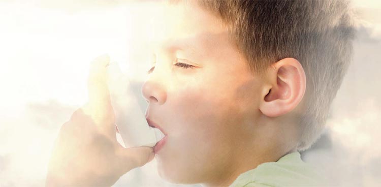 A young boy using an asthma inhaler