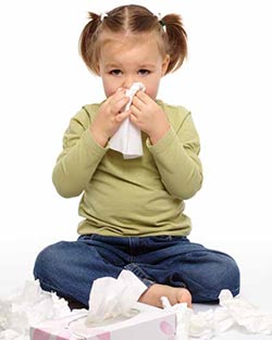 a little girl blows her nose to relieve the discomfort of allergies