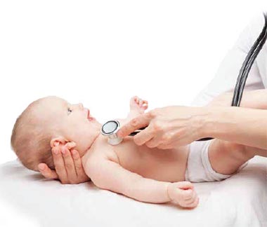 A pediatrician using a stethoscope to listen to a baby's heart during a checkup