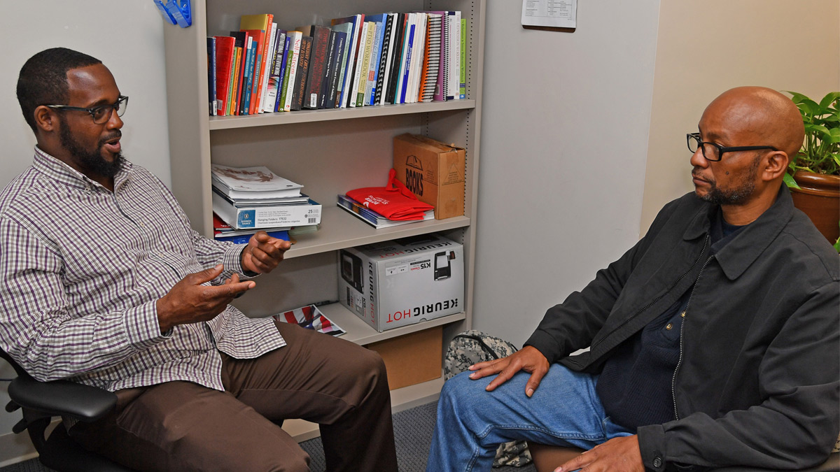 Peer Support Specialist Tyrone Jarmon, left, talks with veteran Gary Chapman.