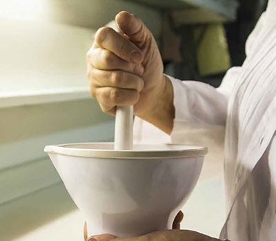 a pharmacist using a mortar and pestle