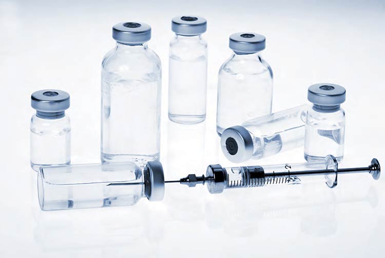 a medical syringe with small glass bottles of medications