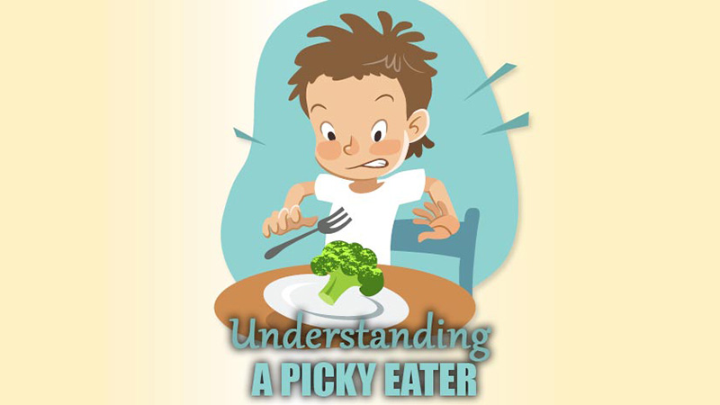 Picky eater: a youg boy pulls away from broccoli