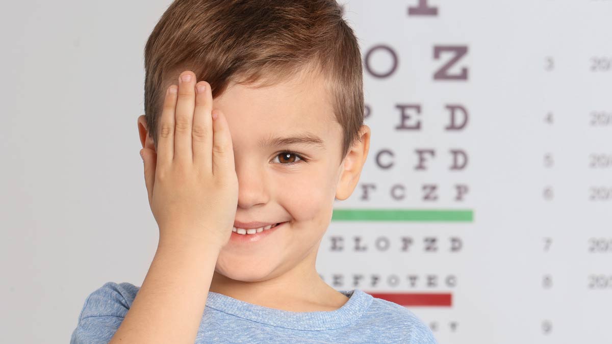 A young boy smiles for a vision screening test