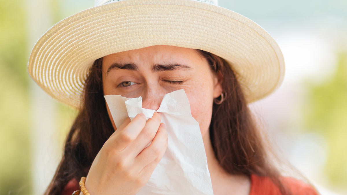 A girl with allergies blowing her nose