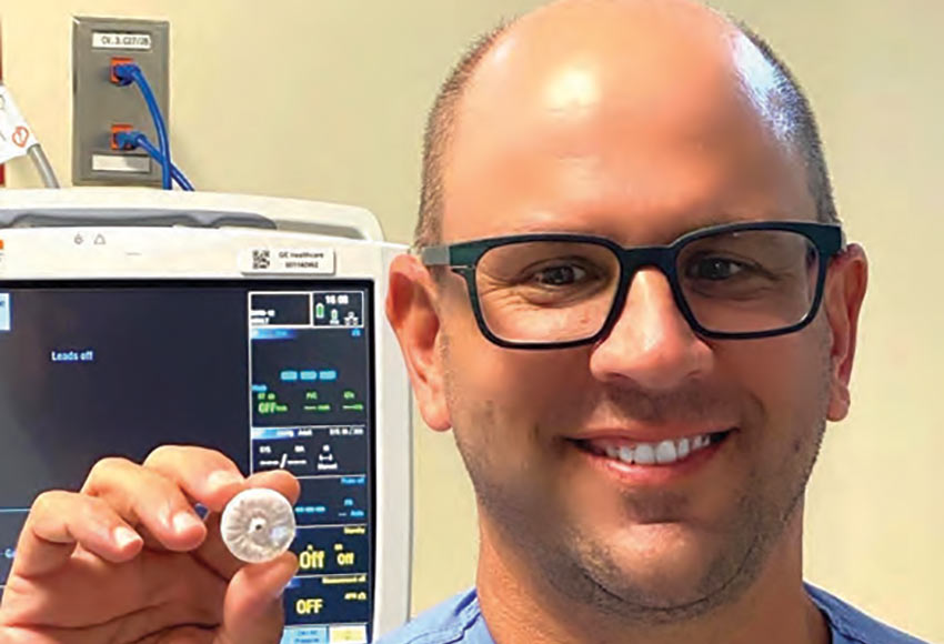 Electrophysiologist Darren Sidney, M.D., with Charleston Heart Specialists holding a WATCHMAN device.