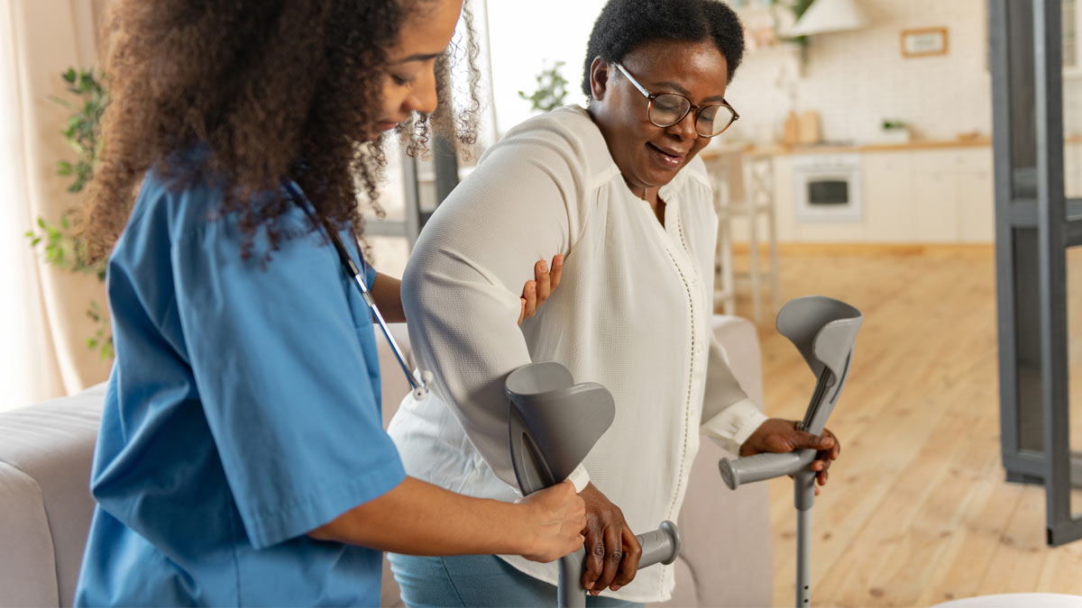 Post-surgery care: A nurse helps a patient with her crutches.