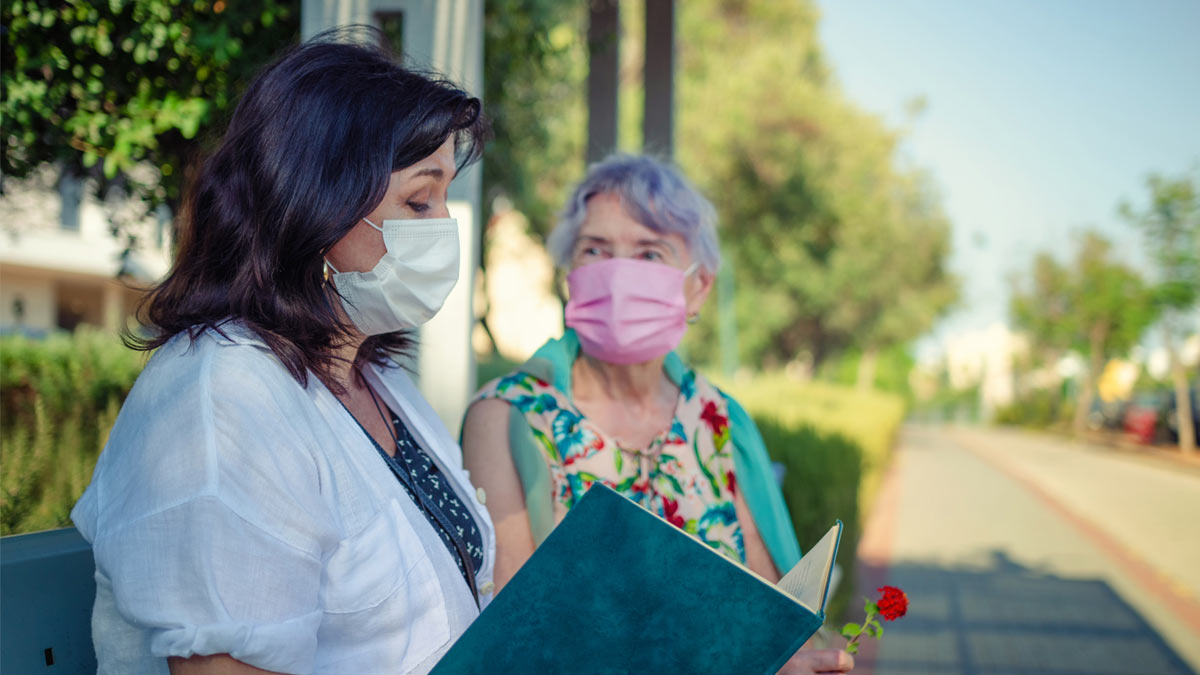 An assisted living resident during the pendemic talking to her activities director.