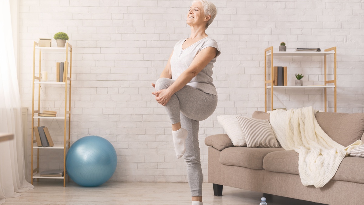 An older woman stretches prior to exercising.