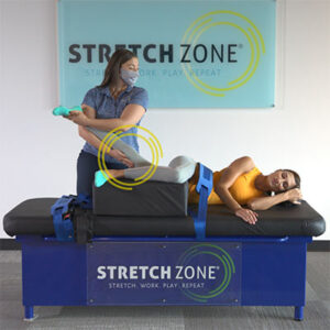 A customer on a stretch table at Stretch Zone with a stretch therapist.