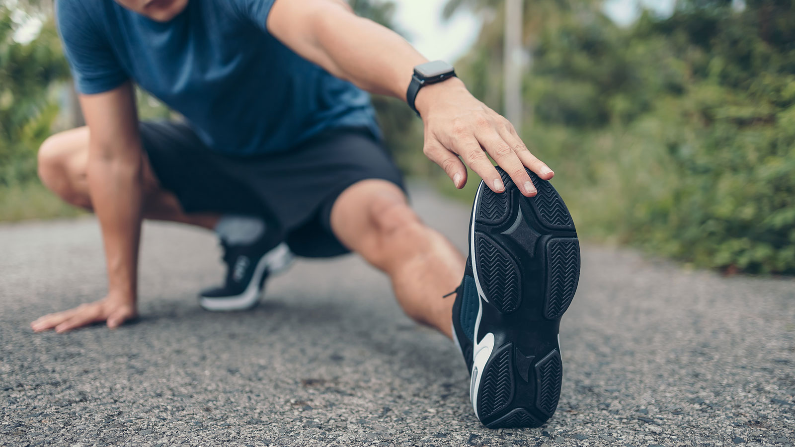 A man stretching in the park before exercising.