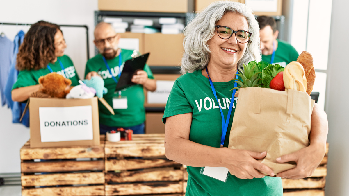 A woman in a volunteer t-shirt is giving back