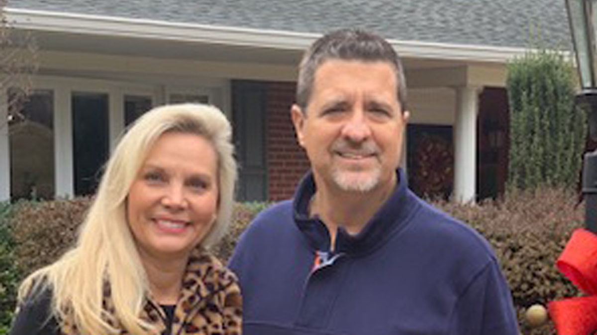 Photo of man and woman in front of a house