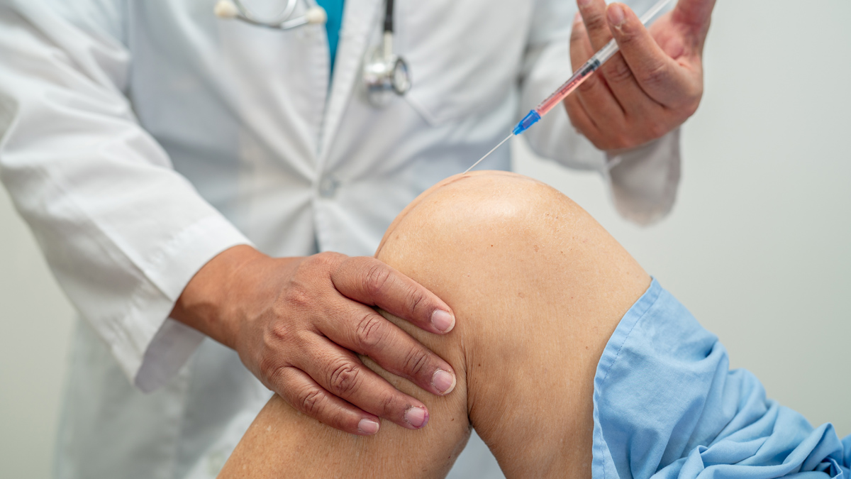 Photo of a doctor injecting a needle into someone's knee