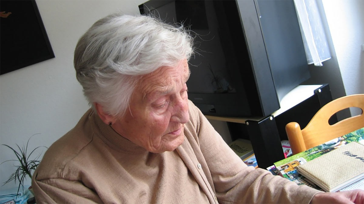 An elderly woman sitting at a table