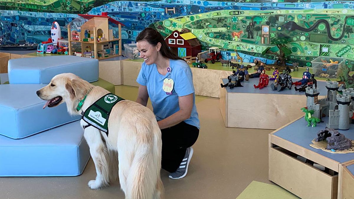 Photo of a healthcare worker with a therapy dog