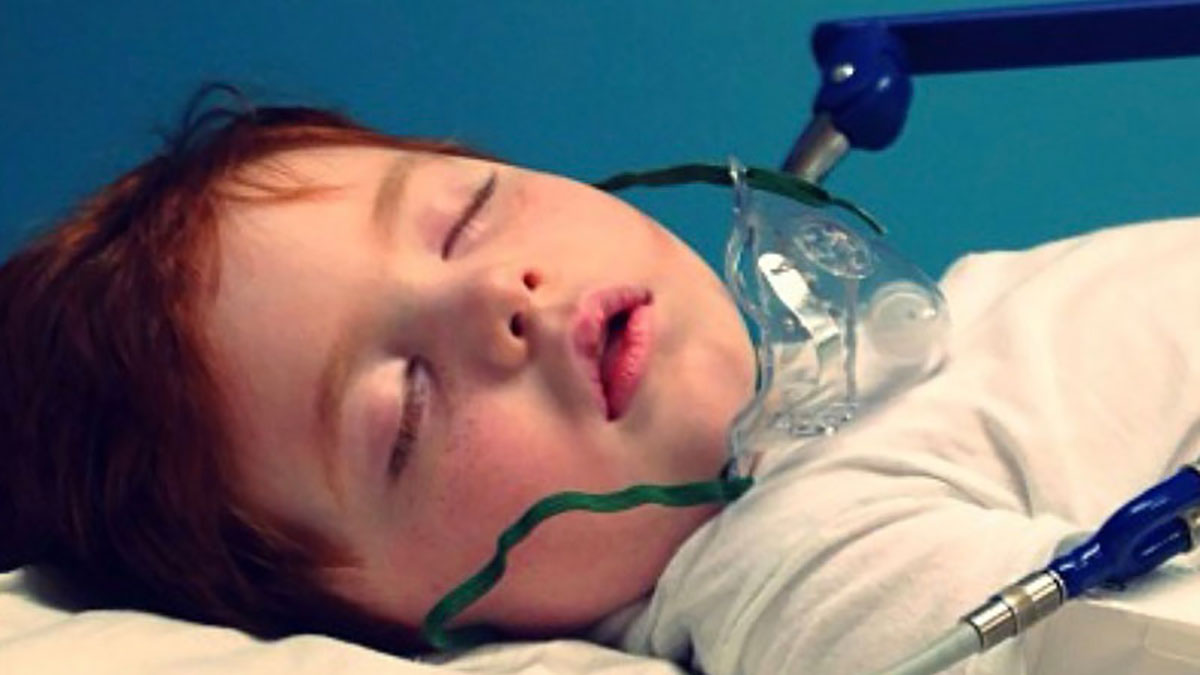 Photo of little boy with an oxygen mask on his face