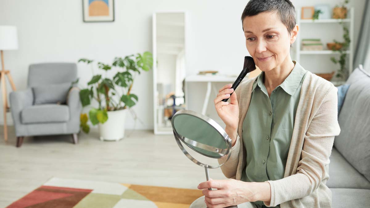 Photo of woman with mirror who is doing her makeup