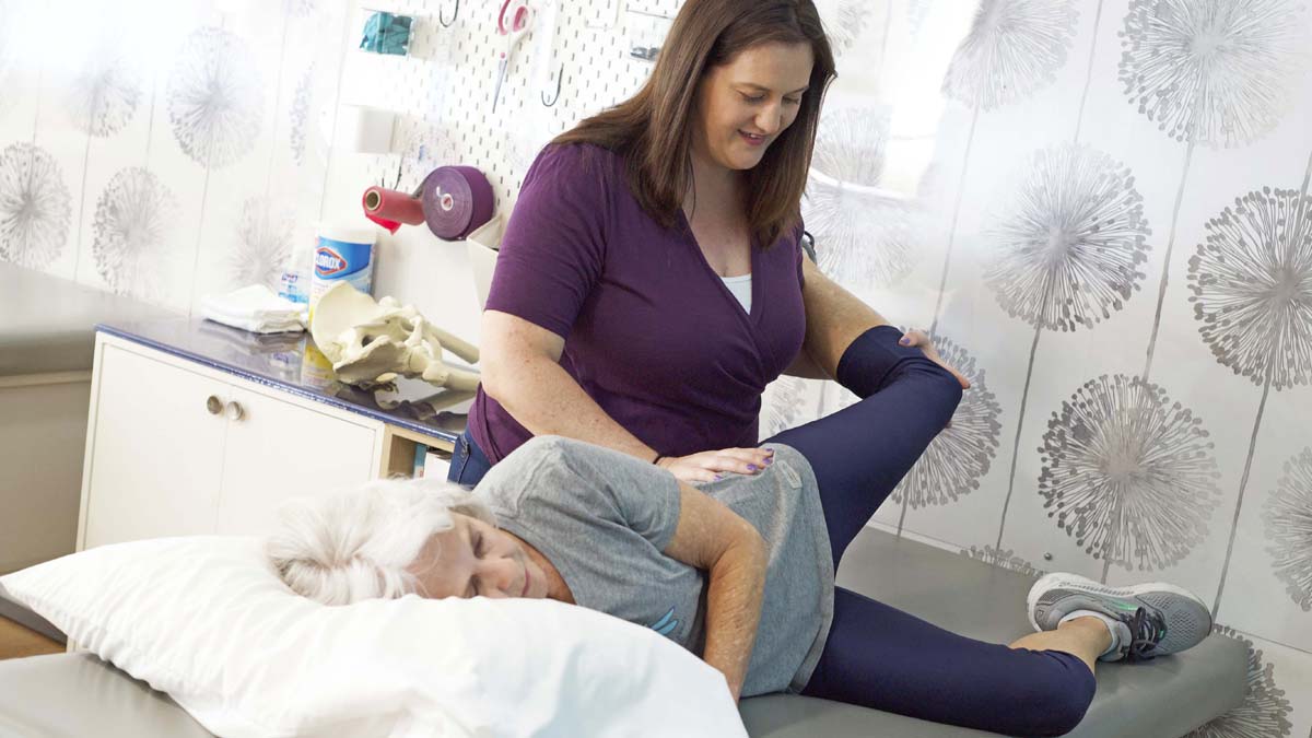 Photo of a woman who is stretching another woman