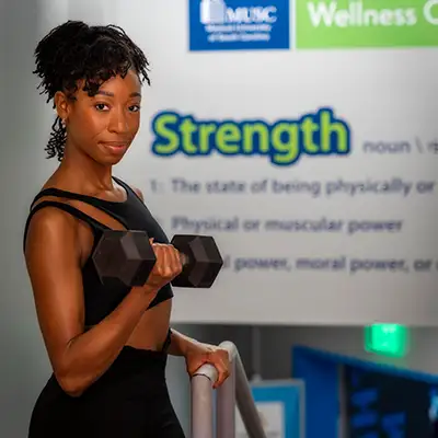 A woman curling a dumbell at MUSC Wellness Center in downtown Charleston, SC