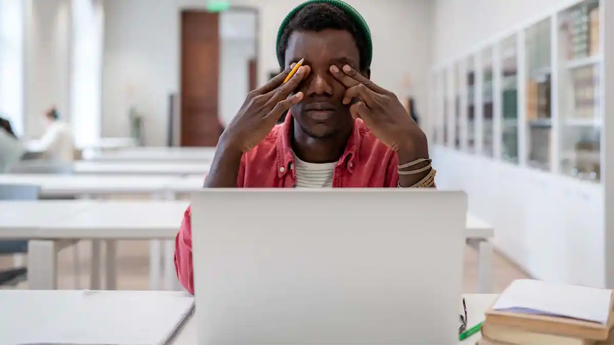 A man rubbing his eyes due to digital eye strain