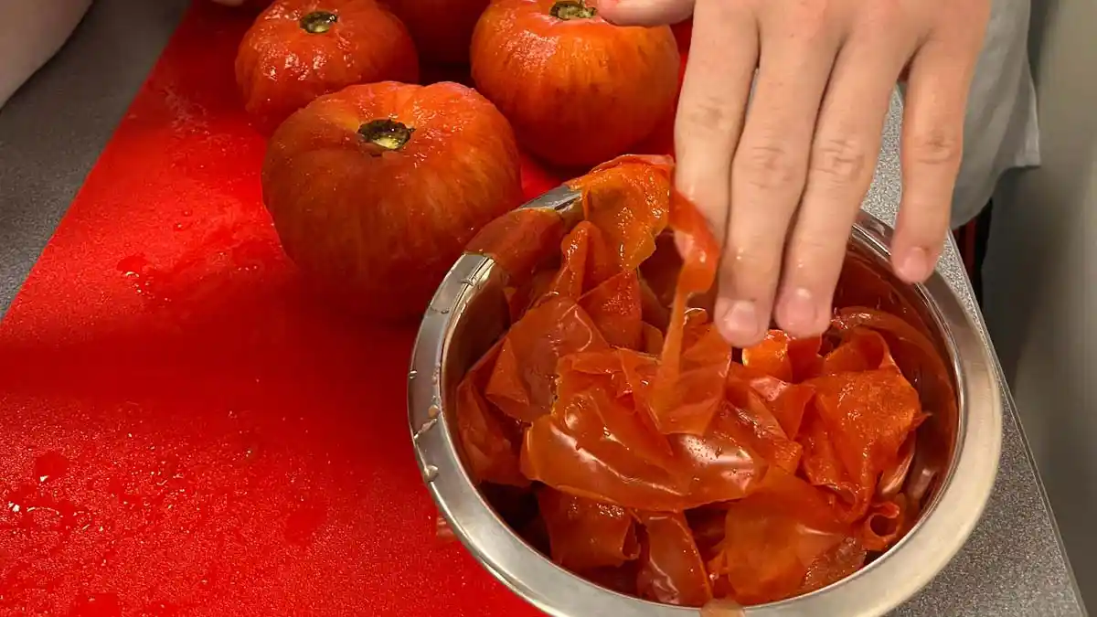 Tomatoes being peeled before being preserved at home.