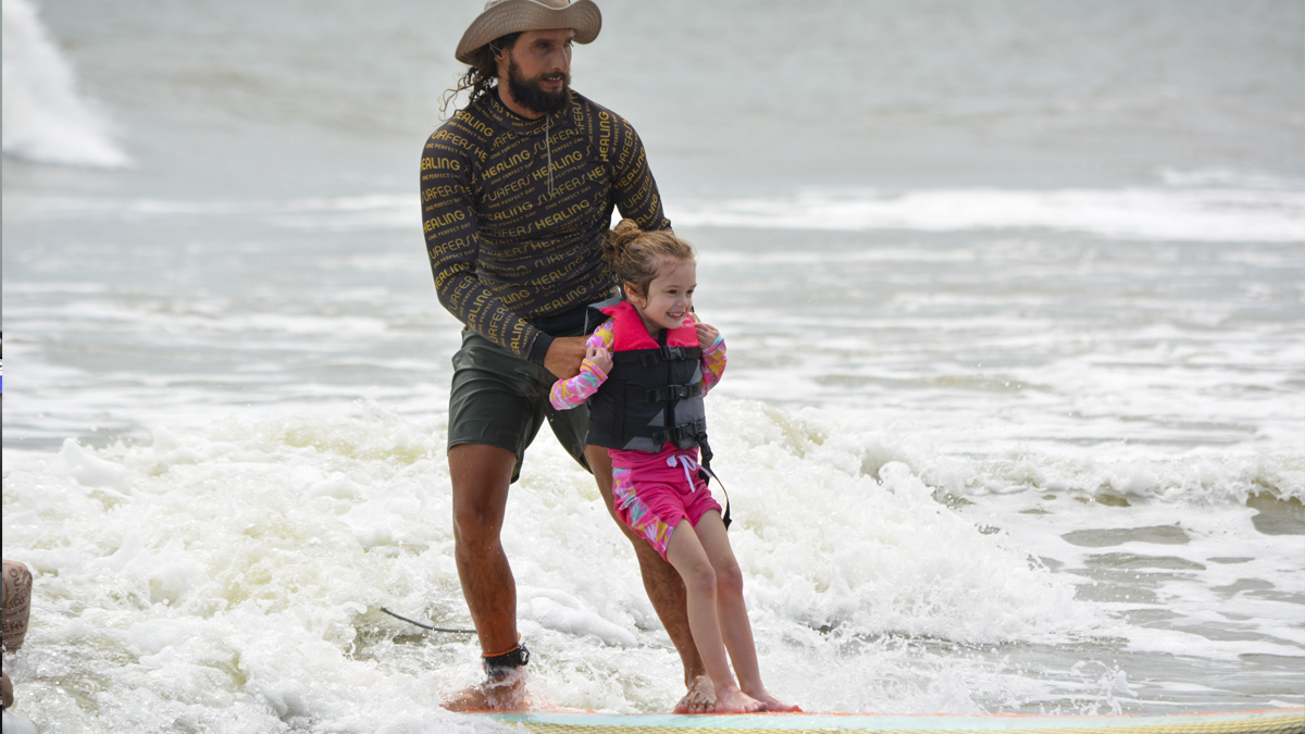 Photo of a man and child surfing