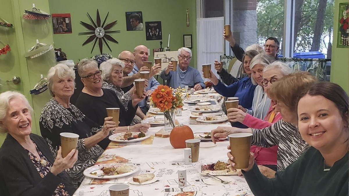 Photo of people at a table with cups in the air