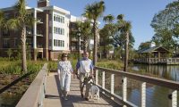 Photo of a man and woman walking with a dog