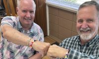 Photo of two men who are fist bumping