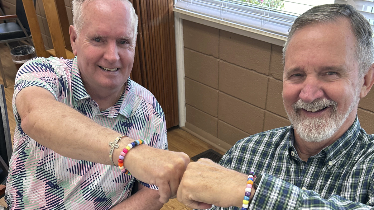 Photo of two men who are fist bumping