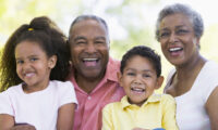 Photo of two older people and two kids smiling