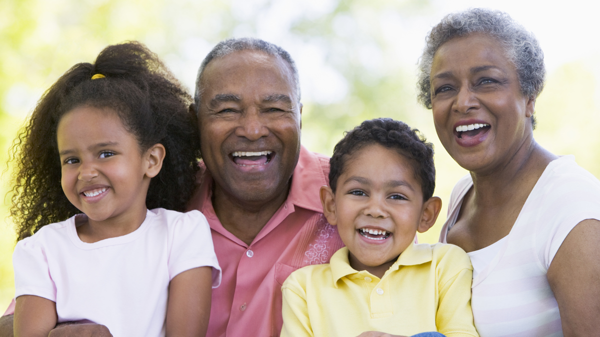 Photo of two older people and two kids smiling